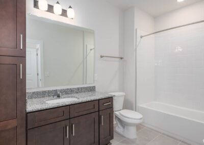 residence bathroom with vanity, linen cabinet, toilet, and bathtub